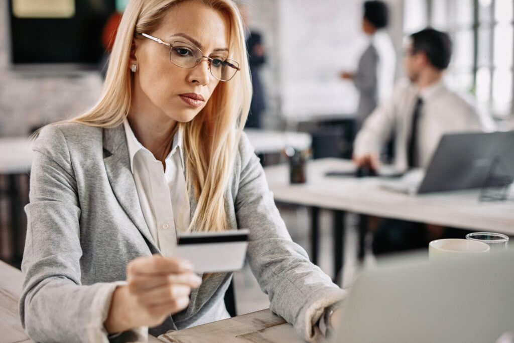 Czym jest upadłość konsumencka? businesswoman holding credit card while using laptop and e banki